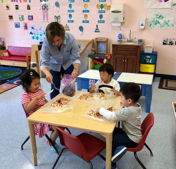 Three children crafting at a table.