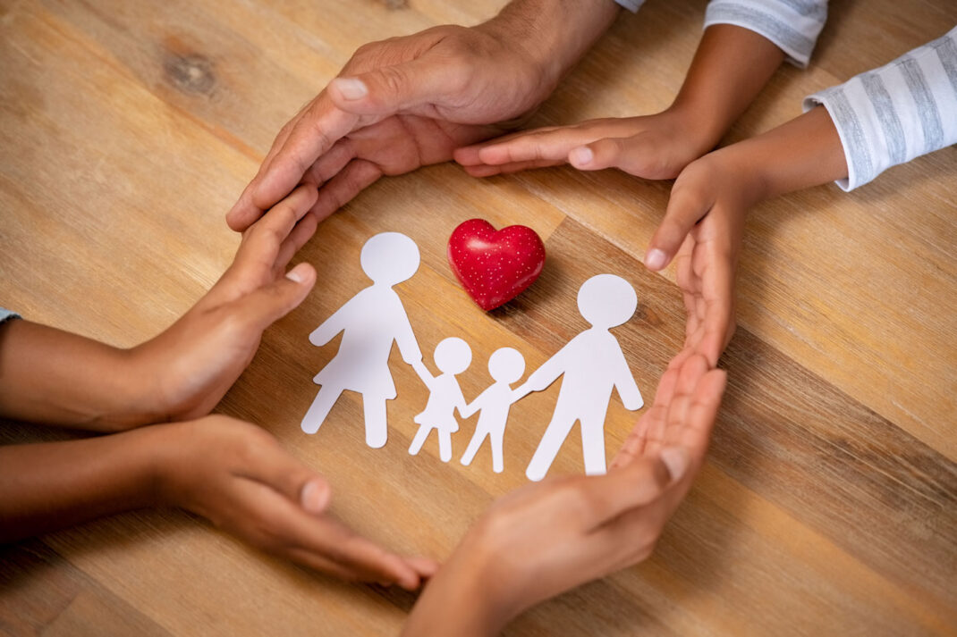 A paper cutout of a family with a heart.
