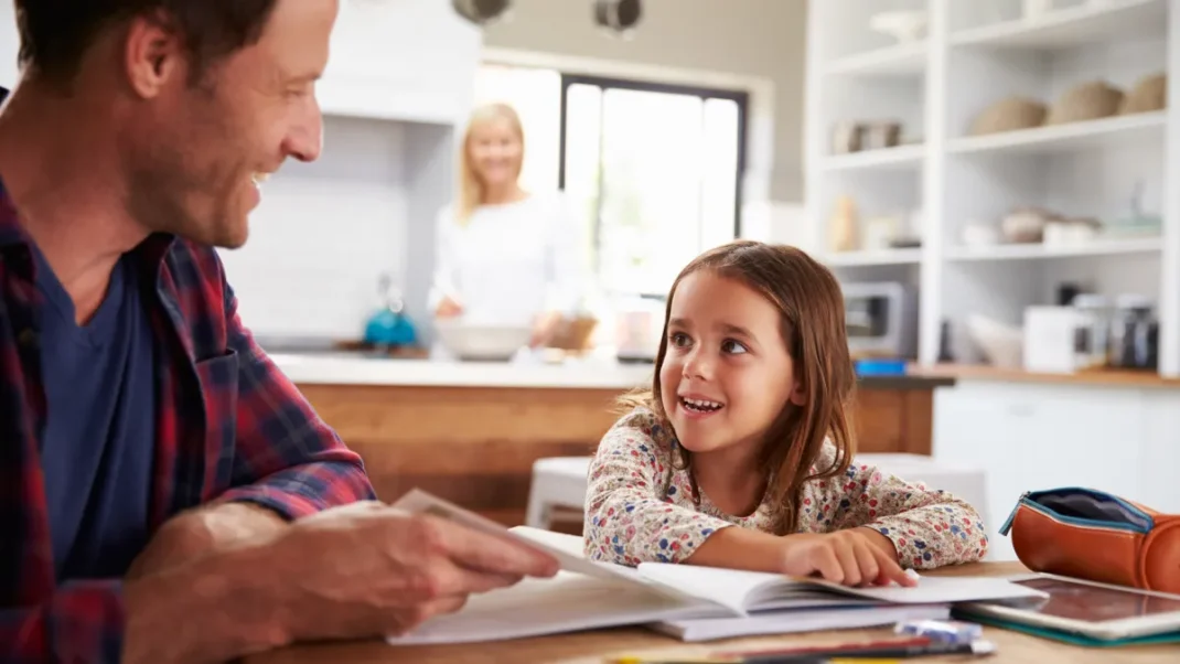 A girl with her father doing homework.