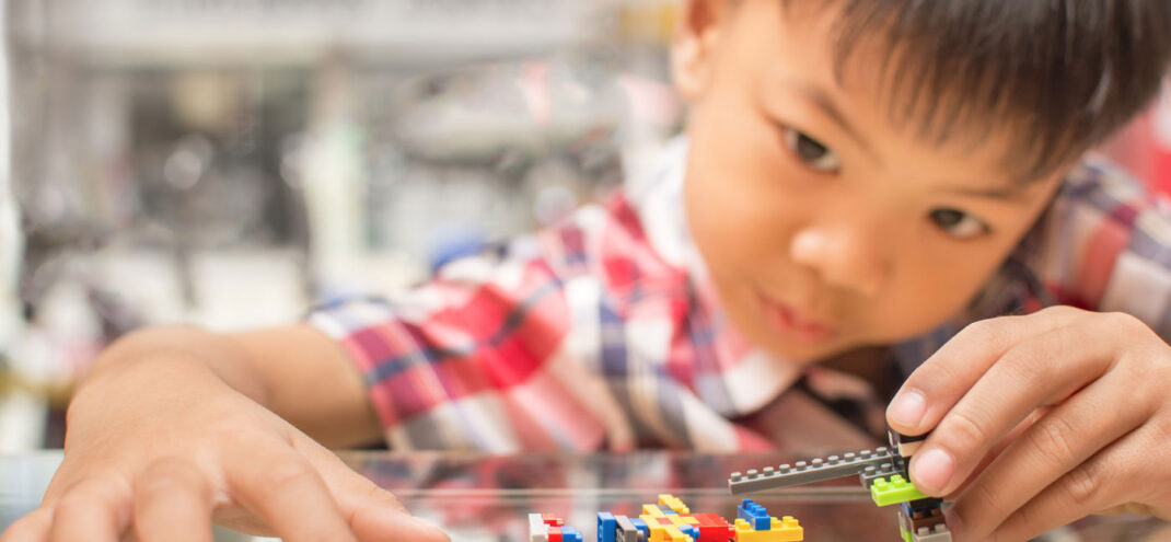 A boy playing with legos.