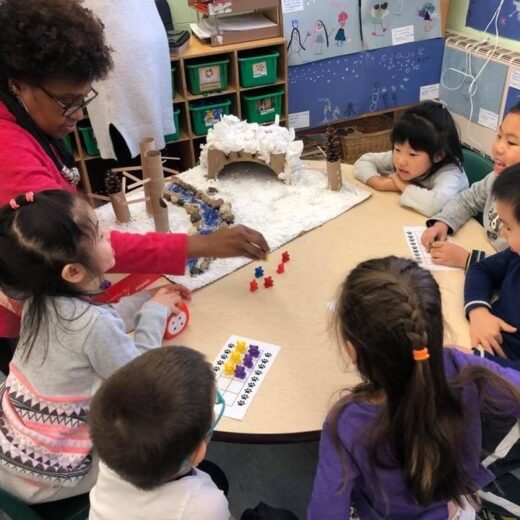 A group of children with an instructor at a table.