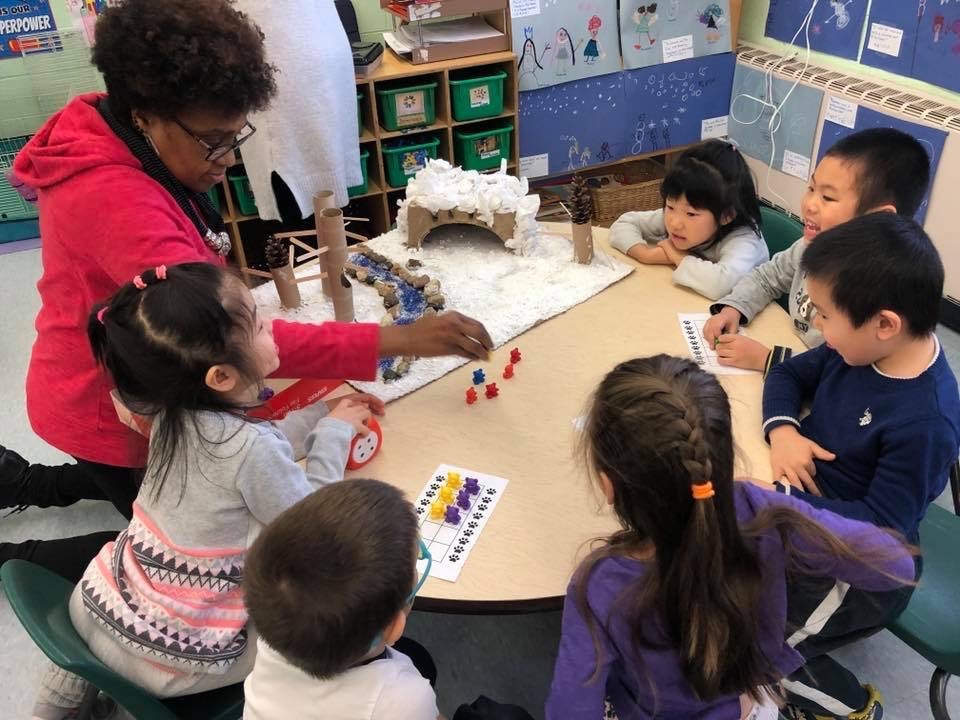 A group of children with an instructor at a table.